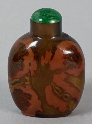 a brown vase with a green lid sitting on a table
