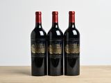 trois bouteilles de vin posées sur une table en bois