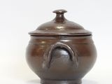 a small brown pot with a lid on a white surface
