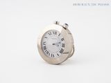 une petite horloge en argent ornée de chiffres romains