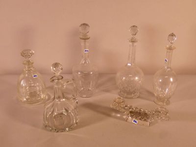 five glass bottles sitting on a table with a chain around them