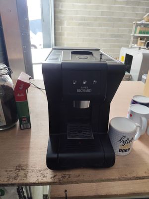 une cafetière posée sur une table à côté d'une tasse