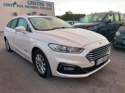 une Ford Monde blanche garée devant un immeuble