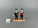 two figurines of two men dressed in black and white