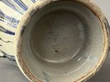 a blue and white vase sitting on a gray surface