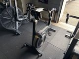 une salle de sport équipée d'un vélo d'appartement et d'un ventilateur