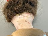 a doll with a hair bun on top of it ' s head