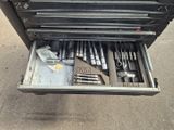 une boîte à outils contenant des outils, posée sur le sol