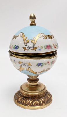 REVEIL contenu dans une boite en porcelaine sphérique sur pi…