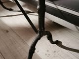 a black bench sitting on a wooden floor next to a black couch