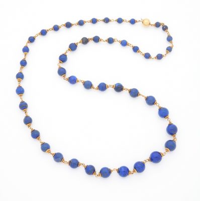 un gros plan d'un collier de perles bleues sur fond blanc