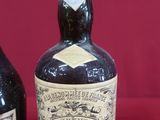 two bottles of liquor sitting next to each other on a red surface