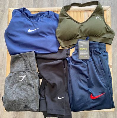 several pairs of women ' s nike sports clothing laid out on a wooden tray
