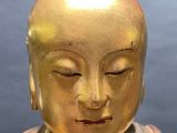 a gold statue of a person with his eyes closed