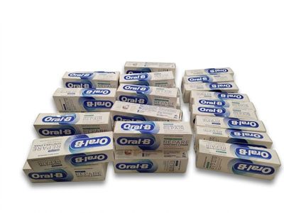 plusieurs tubes de dentifrice empilés les uns sur les autres sur une surface blanche