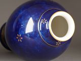 a blue vase with a gold decoration on it