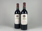 two bottles of red wine sitting next to each other on a table
