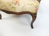 une petite chaise dont l'assise est recouverte d'un tissu à motifs floraux