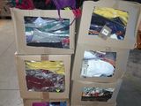 Des cartons de vêtements sont empilés les uns sur les autres dans un entrepôt