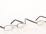 two pairs of glasses sitting on top of a white surface
