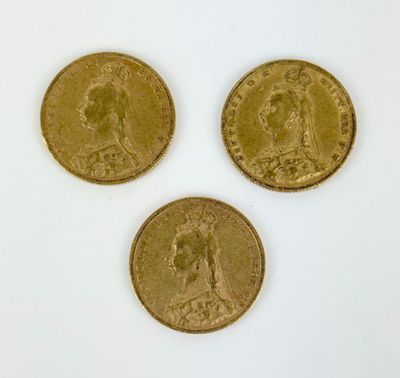 three gold coins are shown on a white surface