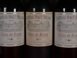 several bottles of red wine are lined up on a shelf