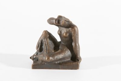 sculpture en bronze représentant une femme assise sur un rocher, les jambes croisées
