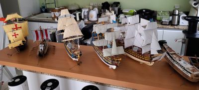 plusieurs maquettes de bateaux posées sur un plan de travail dans une cuisine