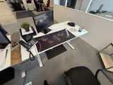 a desk with two computers and a phone on it