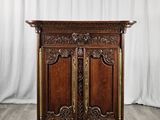 une vieille armoire en bois avec des sculptures et des gravures sur les portes
