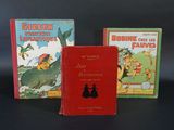 trois livres pour enfants sont posés sur une surface noire
