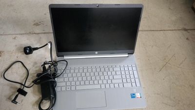 a laptop that is sitting on the ground with a charger