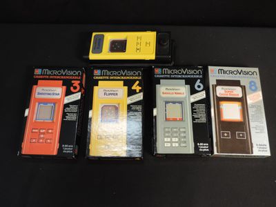 four nintendo game consoles are lined up on a black table