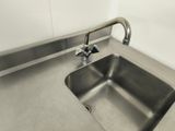 a stainless steel sink with a faucet in the corner