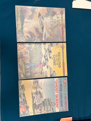 un classeur bleu contenant plusieurs livres et une paire de ciseaux