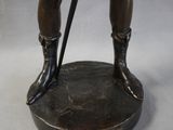 bronze statue of a man with a cane and boots on top of a base