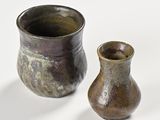 two vases sitting next to each other on a white surface