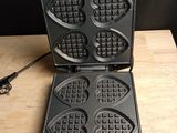 a close up of a waffle maker on a wooden table