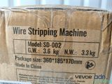 a cardboard box with a wire striping machine on it