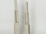 une paire de sculptures en bois blanches posées sur une surface blanche, avec un fond blanc