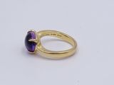 a close up of a gold ring with a purple stone
