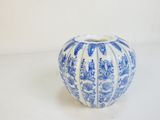 un vase bleu et blanc posé sur une surface blanche