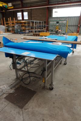 un grand bateau bleu posé sur une table dans un entrepôt