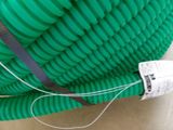 a green hose that is attached to a wall