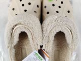 two pairs of crocs slippers on a plastic bag