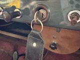 a clock on the dashboard of a car with a keychain hanging from it
