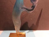 a glass sculpture on a gold plate on a table