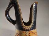 a black and brown vase with a design on it