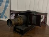 a camera sitting on a wooden table in front of a picture