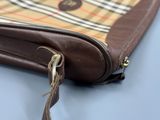 a brown purse with a brown handle on a blue table